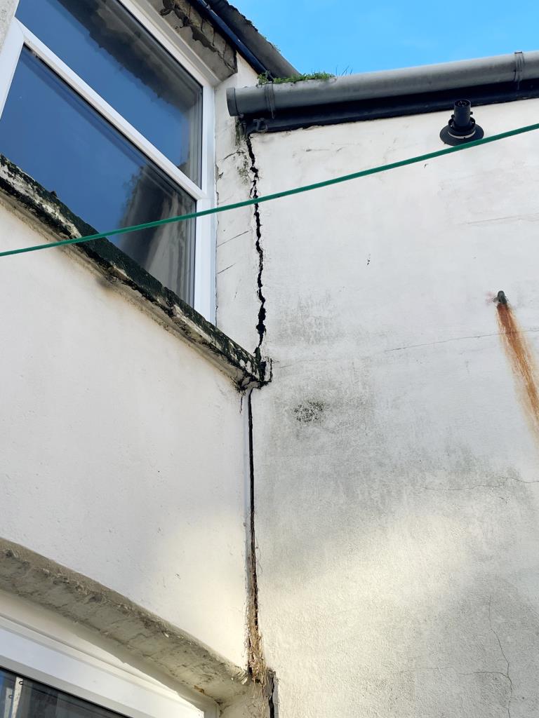 Lot: 68 - MID-TERRACE HOUSE FOR IMPROVEMENT AND REPAIR - Crack on external rear wall